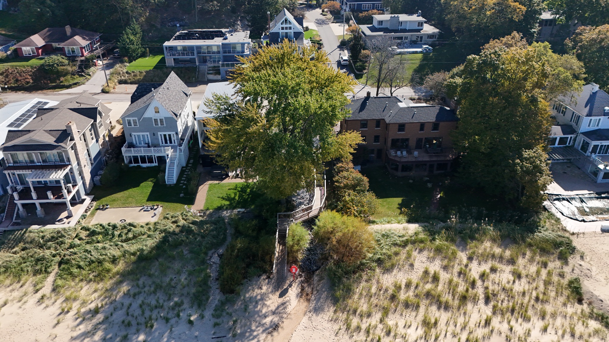 View from the beach toward the Stop 17 and 18 drainage project area, showing established vegetation, stone protection, and beach-access decking · October 23, 2026